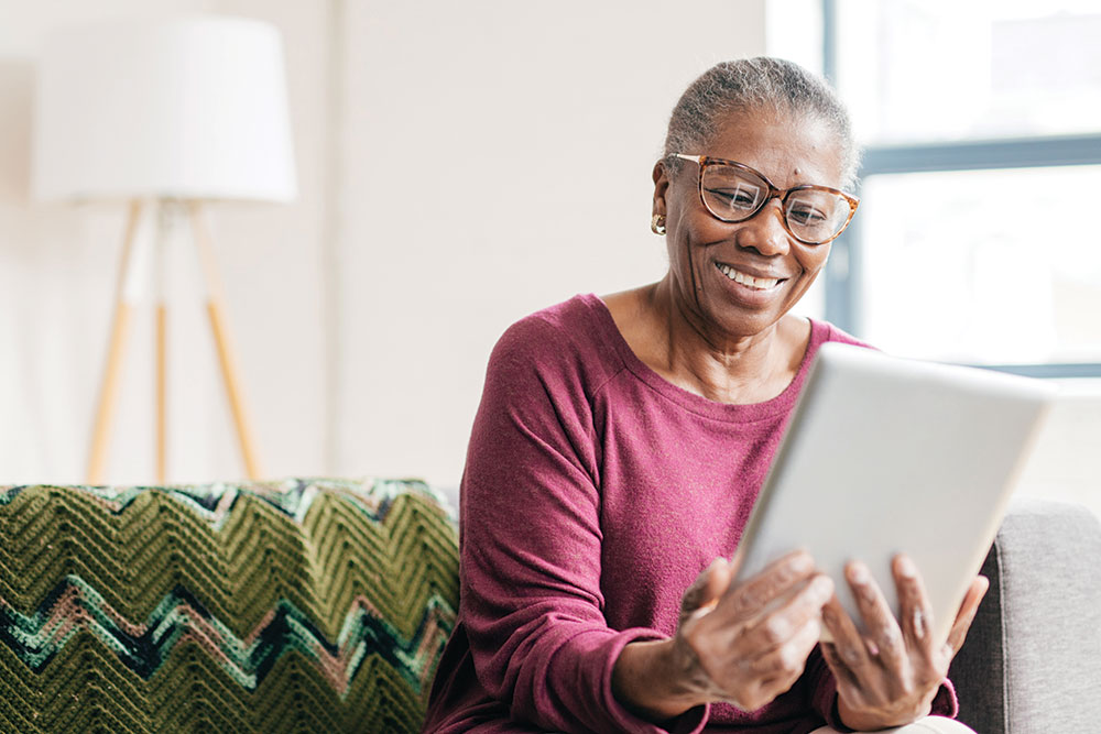 Resident using a digital tablet to stay connected at Charter Senior Living of Newport News in VA.