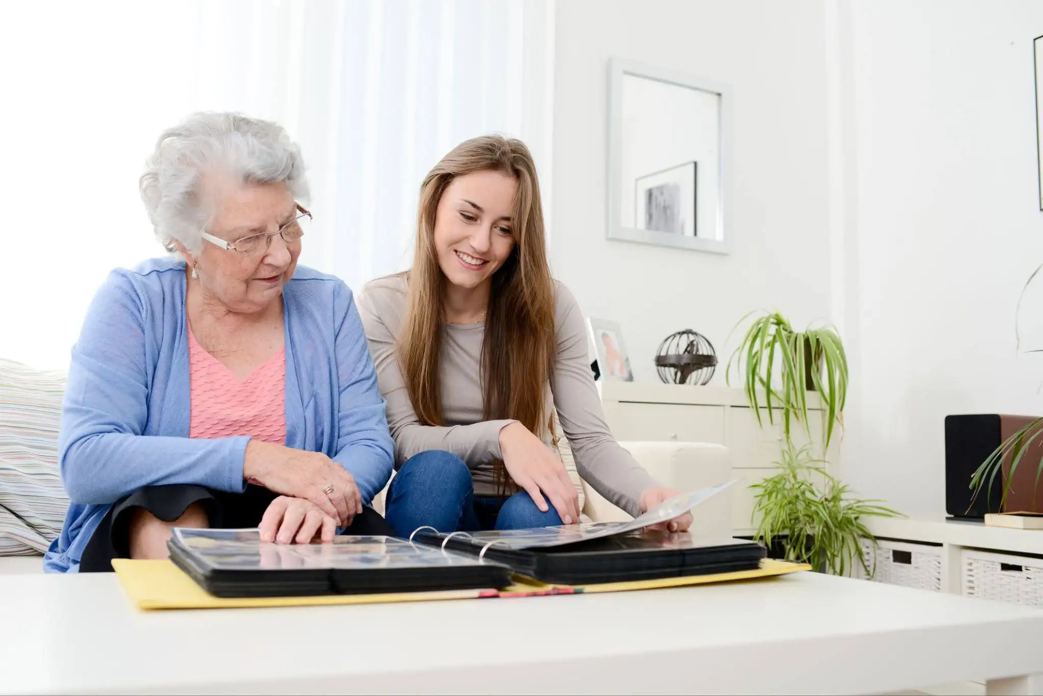 Charter Parent with Dementia Blog Featured Image Senior woman browsing a photo album with her adult daughter